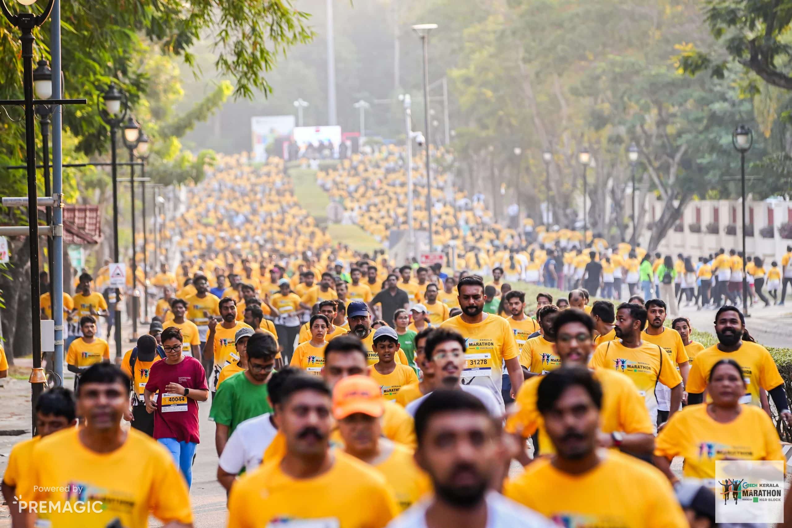Runners in yellow GTECH Kerala Marathon shirts on a city road